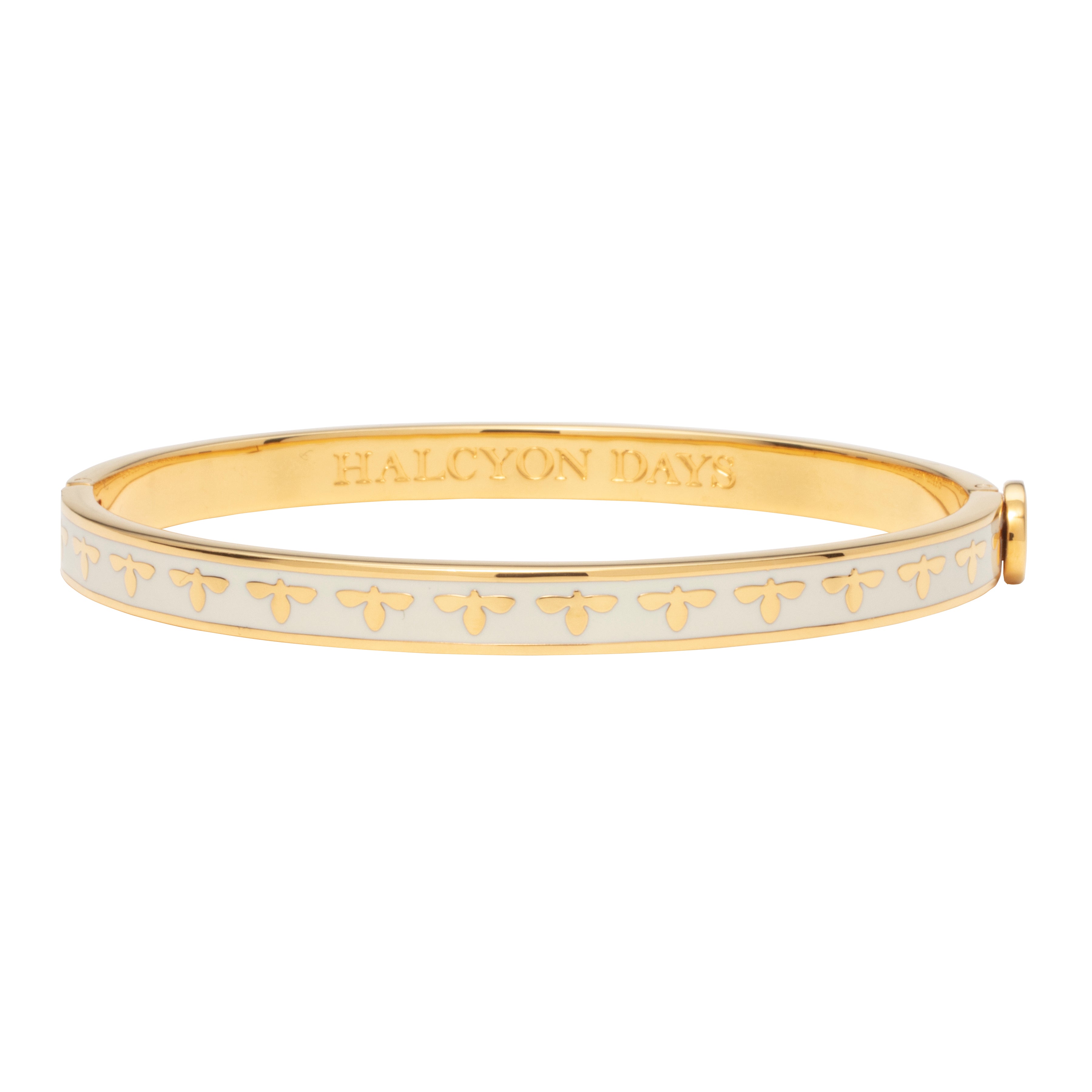 A gold bangle bracelet with a cream-colored bee design and enamel decoration.