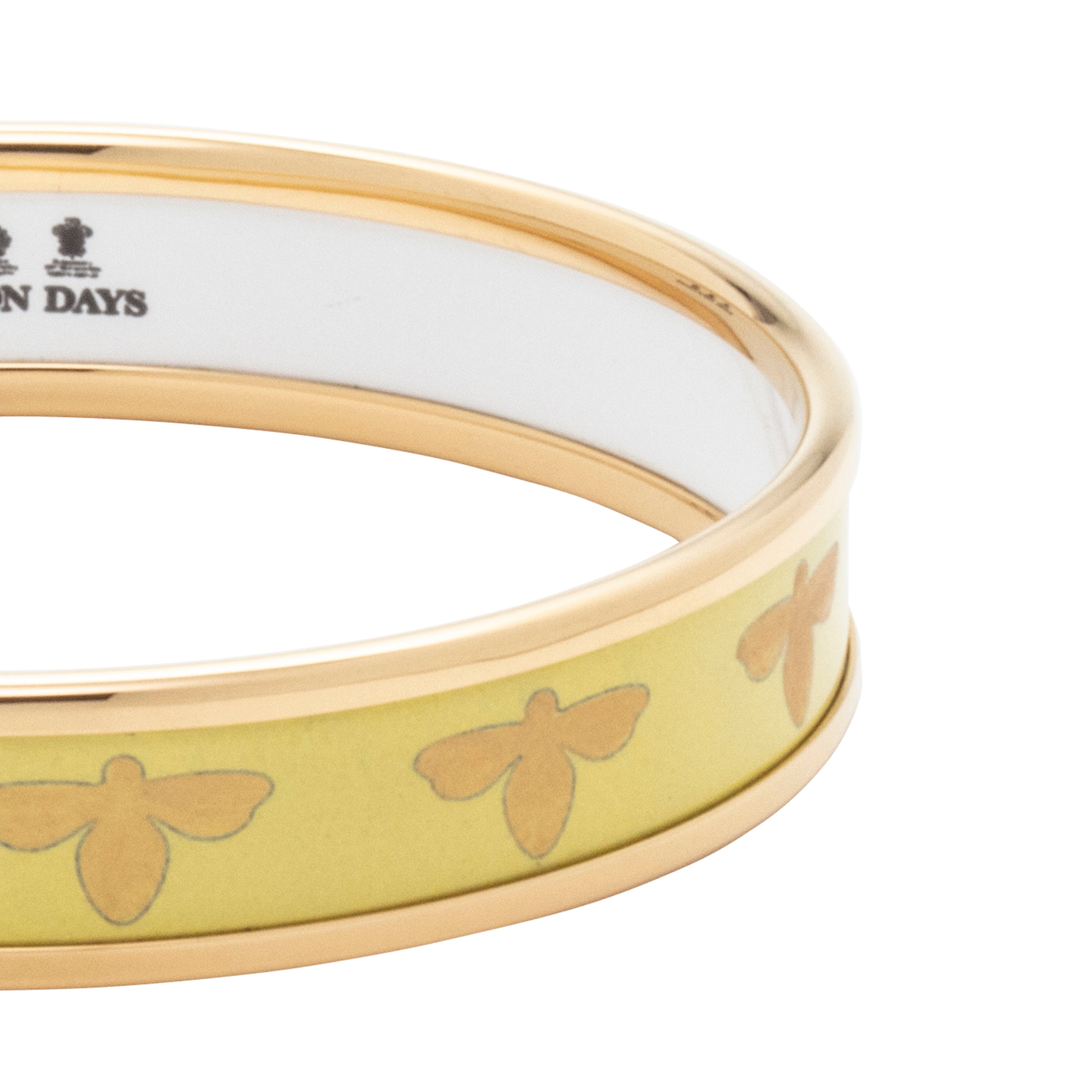 Close up of Halcyon Days bee buttercup and gold enamel bangle